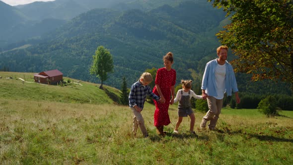 Carefree Family Walk Together on Green Slope