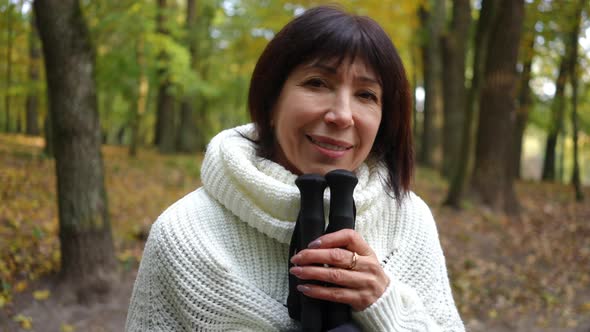 Smiling Mature Happy Woman Posing in Autumn Park with Poles for Nordic Walking