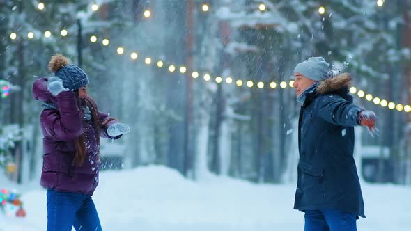 Couple Plays Snowballs on Skating Rink