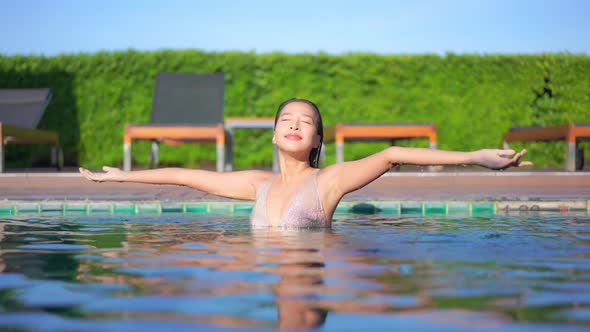 Young asian woman enjoy around outdoor swimming pool for leisure