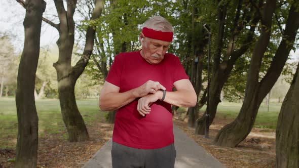 Senior Old Man Running in Park and Using Smart Watch, Tracking Result After Fitness Workout