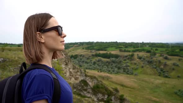 Caucasian Woman with Backpack Watching Green Landscape