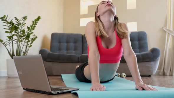 Portrait of Fit Woman Training in Her Living Room with Laptop