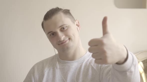 Close-up of Cheerful Young Man Showing Thumb Up at Camera. Portrait of Smiling Young Caucasian Guy