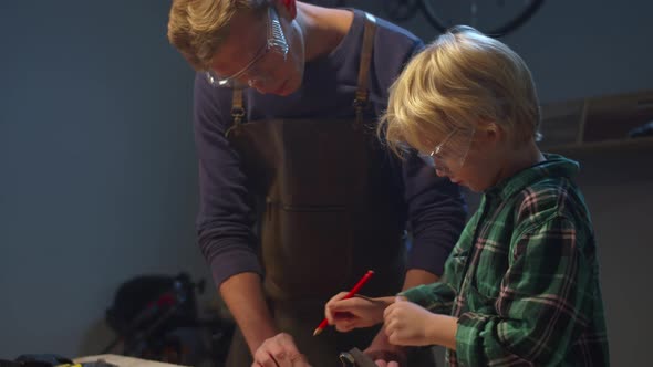 Son and Father Work on a Workbench