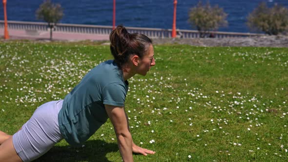 The Girl is Engaged in Sports on the Grass Overlooking the Ocean