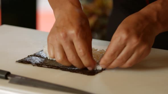 Male Hands Making Sushi.