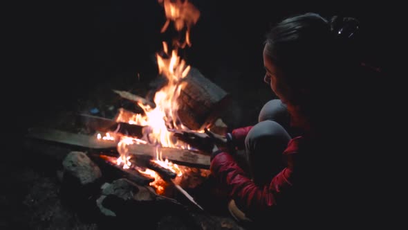 Young Woman in Sitting Near the Campfire