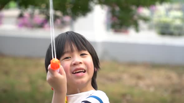 Cute Asian Child Playing With Water Gun In The Summer3