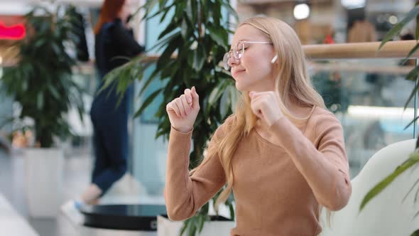 Caucasian Happy Active Exited Girl Dancing to Musical Sound Listen Music in Wireless Headphone Enjoy