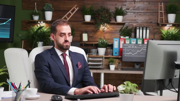 Zoom in Footage of Handsome Guy in Suit Working Alone in the Office