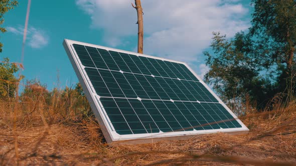 Portable Solar Panel Against Sky and Clouds Lying on the Ground Used in Tourism