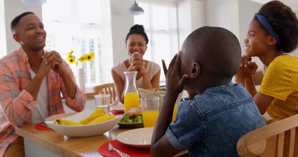 Front view of happy black family having food at dining table in a comfortable home 4k