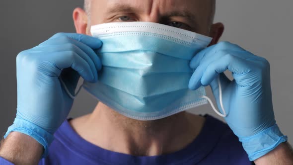 Confident Young Surgeon Doctor in Latex Protective Gloves Wearing Medical Mask on Face