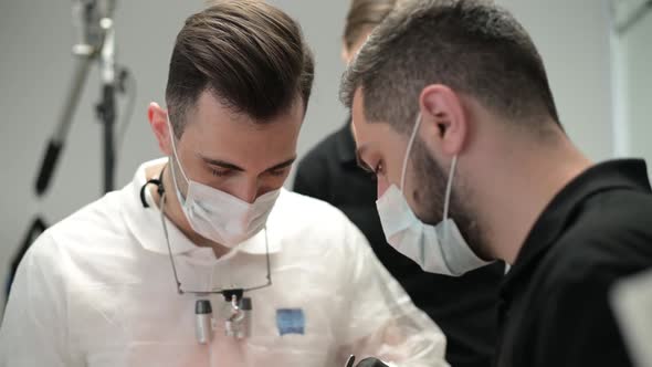 doctor, surrounded by assistants, performs an operation