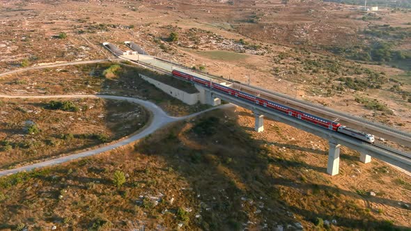 Train passing trough the tall bridges in the Judea valleys of Israel, aerial drone view