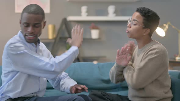 Angry African Man Talking to African Woman While Sitting on Sofa