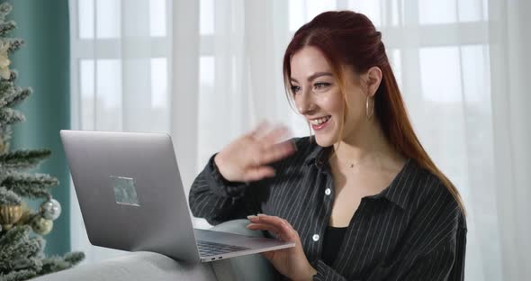 Portrait of Cheerful Young Woman Waving and Talking at Selfie Camera on Laptop. Happy Smiling