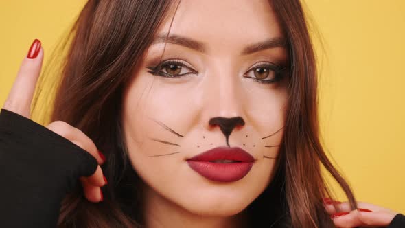 Pretty Young Woman in Cat Woman Cstume Preparing in an Orange Studio