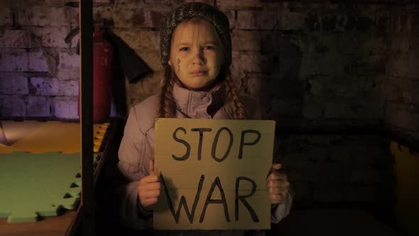 Ukrainian girl kid protesting war conflict raises banner with inscription