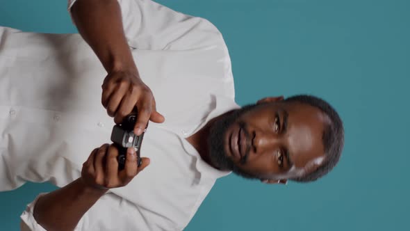 Vertical Video Modern Person Using Controller to Play Video Games in Studio