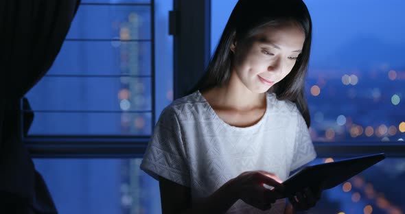 Young woman use of tablet computer at night