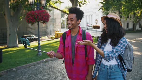 Afroamerican Man and Woman Recording Video for Subscribers on Mobile Phone While Walking Along City