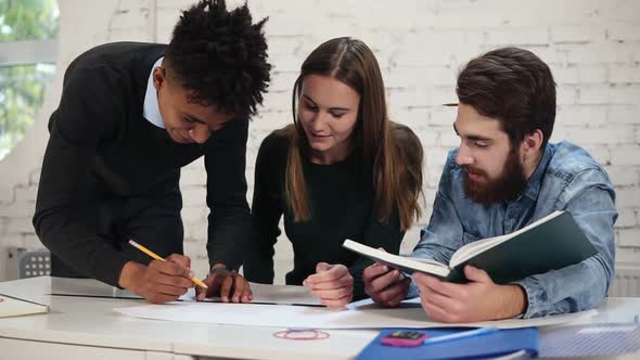 Diverse Group of People Working Together Drawing a Plan Working on Project