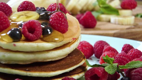 Pouring Honey on Stack of Pancakes