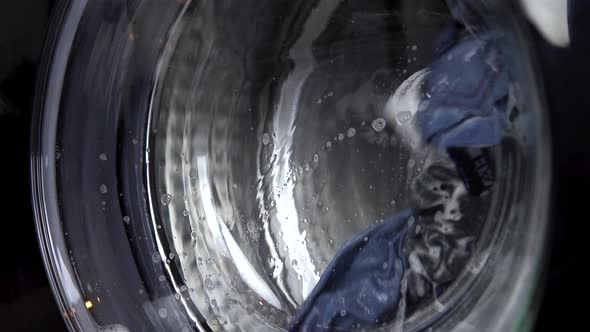 The Washing Machine Is Working. A Washing Machine Spins a Drum Filled with Clothes. Drum Close Up