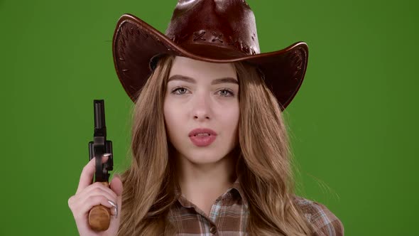 Sheriff Girl Holds a Revolver in Her Hands and Aiming at the Villain. Green Screen. Slow Motion