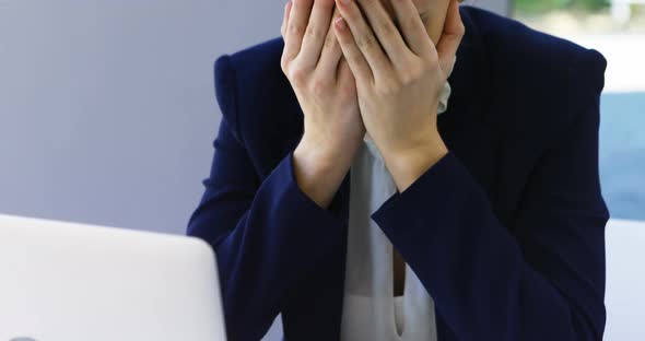 Businesswoman crying at desk 