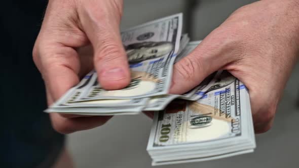 businessman counts a bundle of cash hundred-dollar bills of the USA. close-up. selective focus.