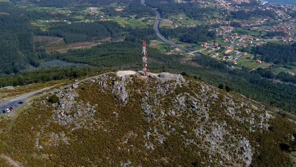 Aerial View Of Telecommunications Mast On Rocky Hillside In Miradoiro da Curota. Dolly Back Shot