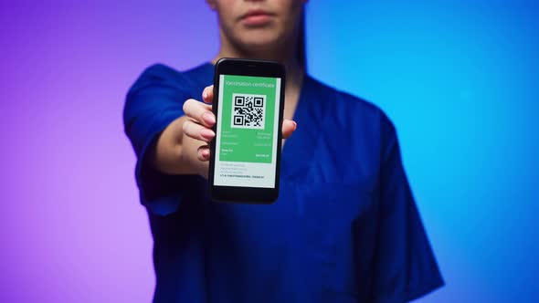 Woman Surgeon in Medical Uniform Showing Vaccination Passport with Qr Code on Phone International