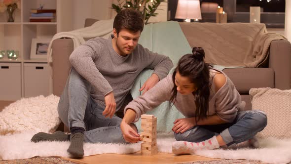 Happy Couple Playing Block-stacking Game at Home