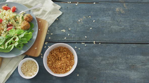 Video of fresh salad with green leaves and bowls with seeds on wooden background