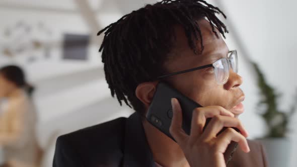 African American Male Manager Talking on Mobile Phone in Office