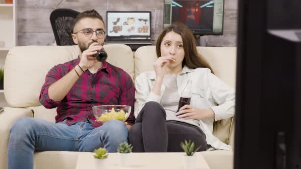 Beautiful Young Couple Sitting on the Couch