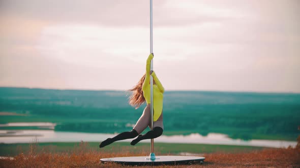 Woman with Long Hair in Yellow Swimsuit Dancing By the Pole
