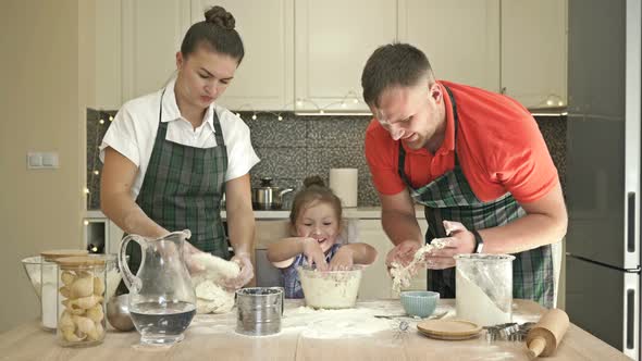 Cheerful Married Couple with a Little Daughter, Cook Some Dough Together, Enjoy Family Activities