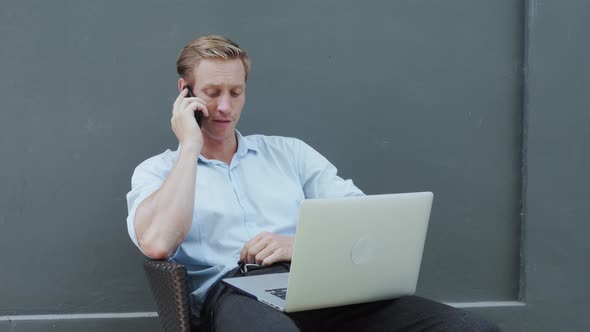 Businessman Working on Laptop and Talking on Phone Handsome Person Talk Mobile