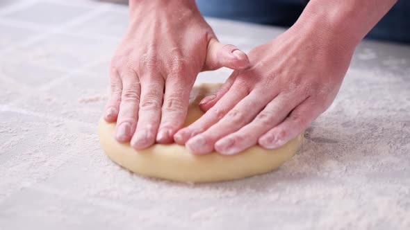 Apple Pie Preparation Series  Women's Hands Kneading Dough on a Table Covered with Flour