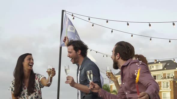 Friends celebrating outdoors with champagne and sparklers