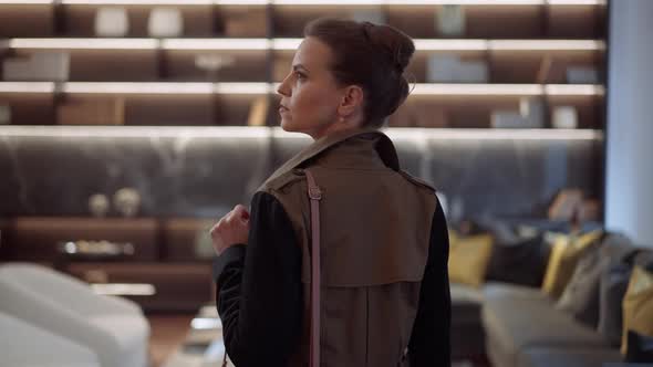 Back View Concentrated Wealthy Woman Entering Furniture Store Showroom Looking Around and Leaving