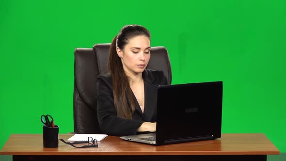 Female Manager Works on a Laptop and Takes Notes. Green Screen Background. Slow Motion