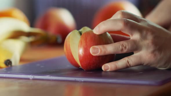 Slicing Apple on Chopping Board Close Up. Healthy Eating, Cooking, Dieting and People Concept.