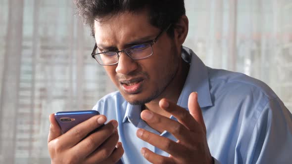 Frustrated Man Reading Bad News on Smart Phone