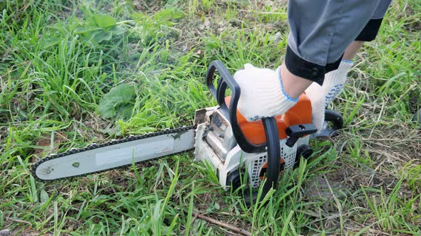 Chainsaw Launch. Unrecognizable Man Pulls Starter