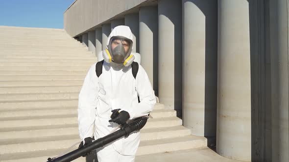 Cleaner with Pressurized Sprayer in Hands Going To Disinfect Public Places.